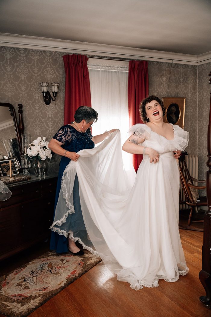 bride's mom helping her into her vintage wedding dress