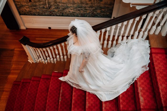 bride walking downstairs in her vintage wedding dress